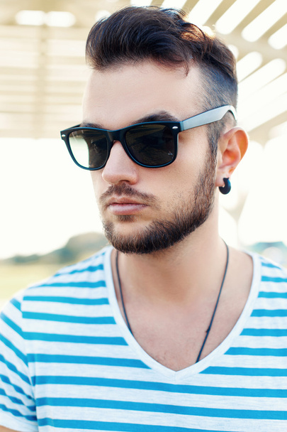 Summer portrait of handsome hipster man in sunglasses with a beard on the beach. - Foto, Imagem