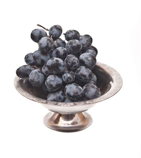 Branch of black grape in metal bowl isolated on white background - Photo, Image