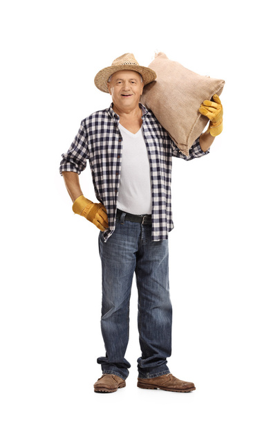 Mature farmer holding a burlap sack - Фото, изображение
