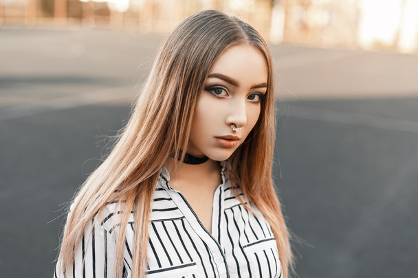 Beautiful young woman with an earring in the nose in a striped blouse - Photo, Image