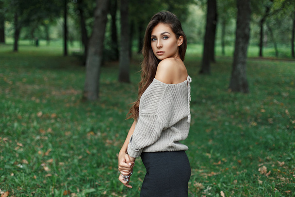 Beautiful young woman in vintage gray sweater posing in the park - Фото, зображення