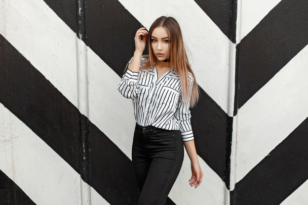 Красива молода дівчина в модній блузці біля дизайну стін з лініями
 - Фото, зображення