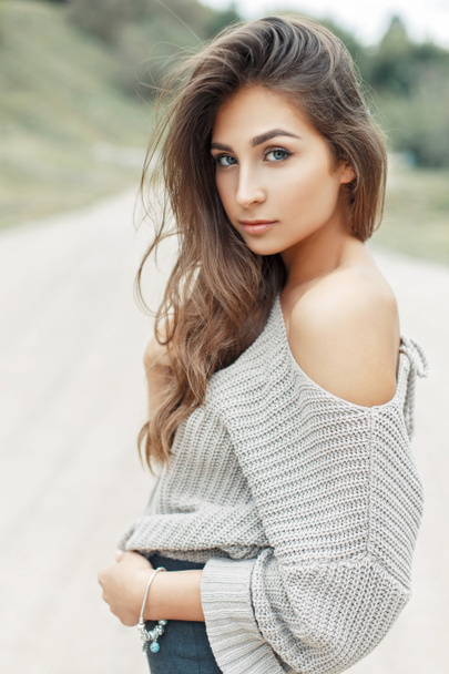 Fiatal csinos nő a szüreti kötött pulóver egy meztelen váll göndör frizura - Fotó, kép
