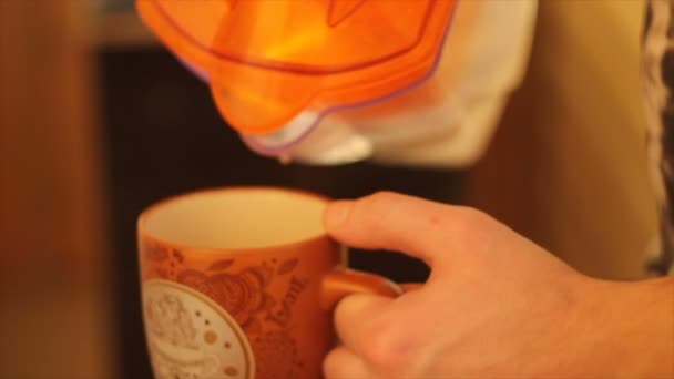 Ein Mann gießt Wasser aus einer Karaffe in einen Becher - Filmmaterial, Video