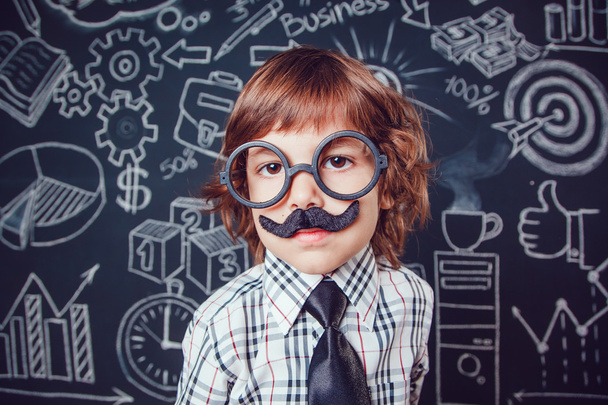 Μικρό αγόρι ως επιχειρηματίας ή δάσκαλο με μουστάκι και γυαλιά που στέκεται πάνω σε σκοτεινό φόντο μοτίβο. Φορώντας πουκάμισο, γραβάτα. γκρο πλαν - Φωτογραφία, εικόνα