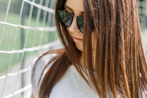 Ritratto ravvicinato di una giovane bella donna con occhiali da sole alla moda nella giornata estiva soleggiata
. - Foto, immagini