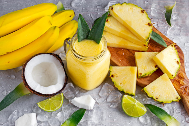 ripe Yellow Pineapple, coconut, Smoothie with slices of Lime and ice. concept healthy food. - Фото, зображення