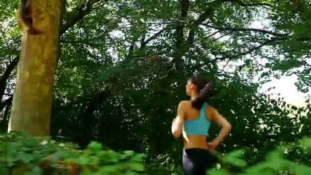 Tracking camera of woman girl running jogging in a green park, slow motion - Video, Çekim