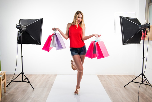 Mujer con muchas bolsas de compras en el estudio
 - Foto, imagen