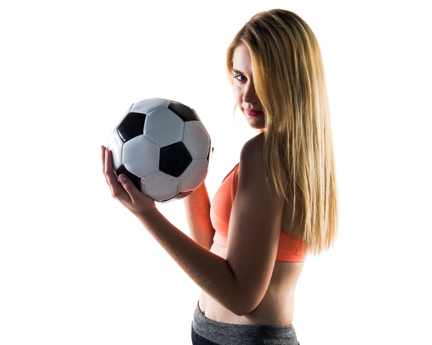 Όμορφη ξανθιά κοπέλα που κρατά μια μπάλα ποδοσφαίρου - Φωτογραφία, εικόνα