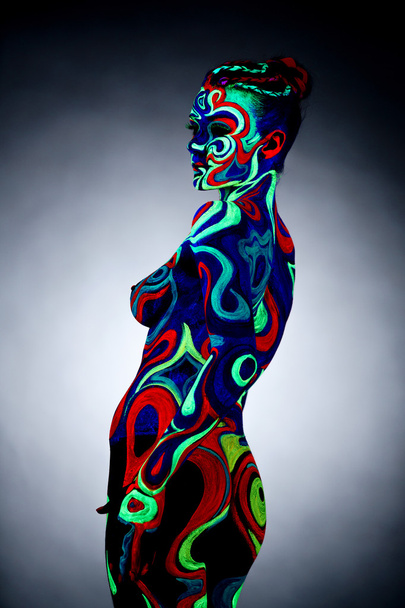 Body art. Portrait of nude girl posing in UV light - Foto, Bild