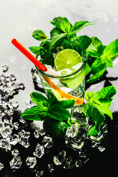 glass of mojito with lime and mint ice cube close-up red straw - Foto, imagen