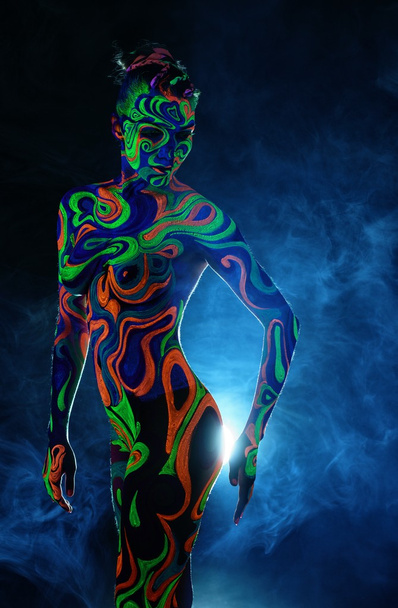 Slim woman posing nude with luminous body art - Fotoğraf, Görsel