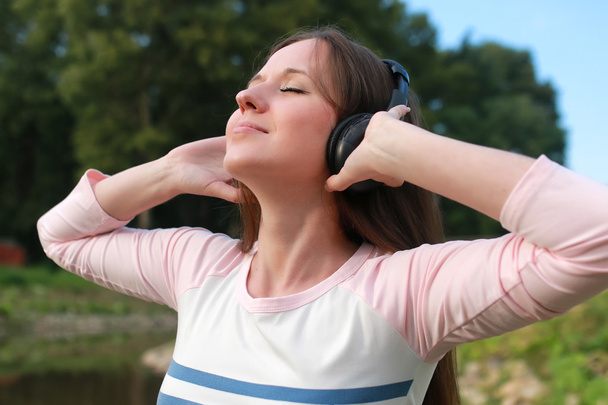 chica escuchar música en auriculares al aire libre
 - Foto, Imagen