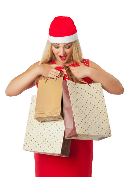 bella ragazza in cappello Babbo Natale helper guardando borse della spesa
 - Foto, immagini