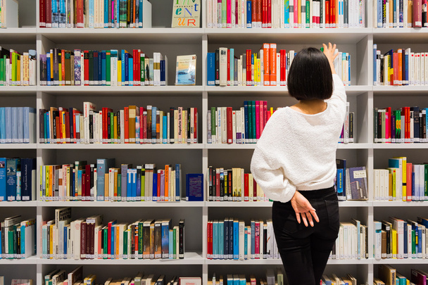 Asyalı kız okuma arama Kitap Kütüphanesi Beyaz Modern şirin Gla - Fotoğraf, Görsel