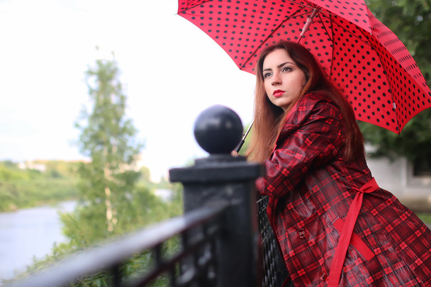 woman with umbrella red on street tree - Φωτογραφία, εικόνα