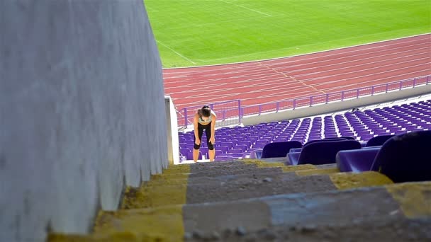 Mujer atleta chica corriendo por las escaleras en un estadio, cámara lenta
 - Metraje, vídeo