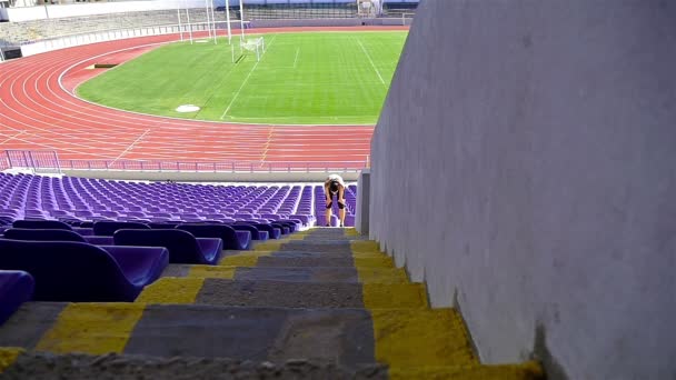 Nő lány sportoló fut fel a lépcsőn a stadionban, lassú mozgás - Felvétel, videó