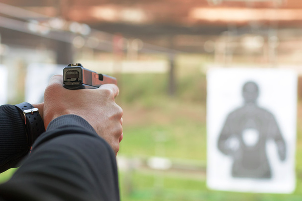 Shooting with a pistol. Man aiming pistol in shooting range. - Фото, зображення