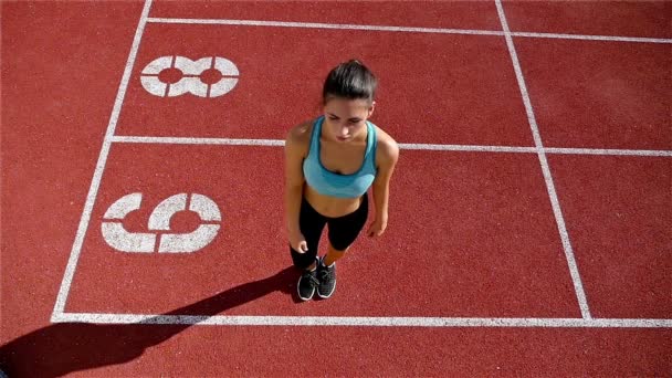 Ángulo bajo de pista atleta mujer calentamiento antes de correr en un estadio, cámara lenta
 - Imágenes, Vídeo