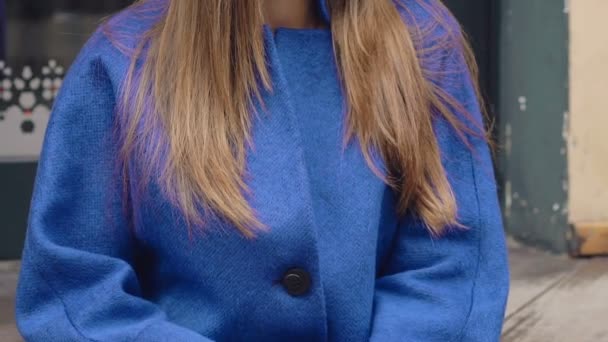 Pretty girl in blue coat posing on the stairs outdoor - Video