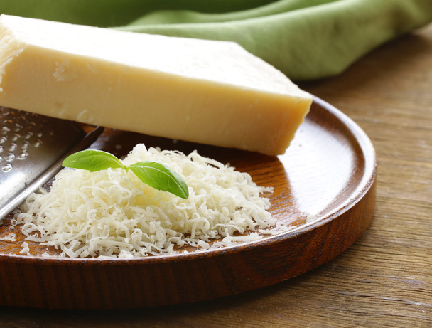 ahşap bir masa üzerine rendelenmiş ve bütün parmesan peyniri - Fotoğraf, Görsel