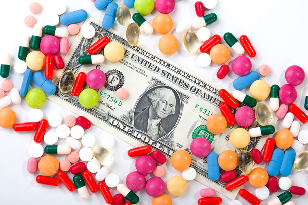 Pills and tablets on white background with dollar bill in vivid  - Foto, imagen