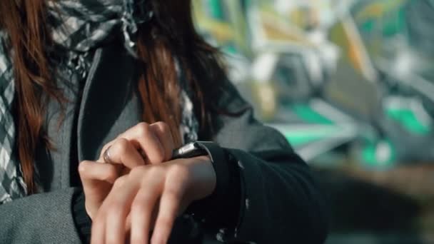 Woman using her smartwatch touchscreen device on a bright background 4k - Felvétel, videó