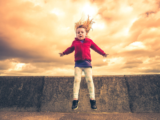 Маленька дівчинка стрибає високо
 - Фото, зображення