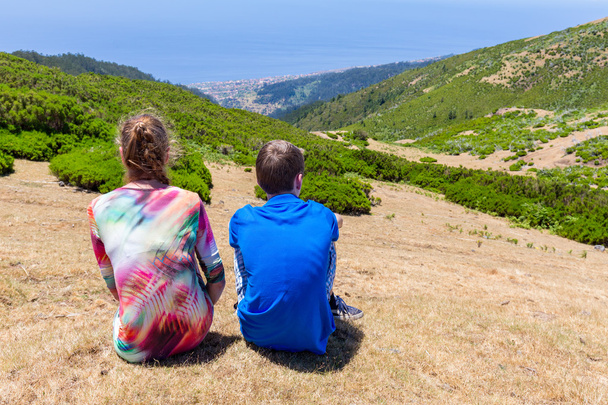 Caucasian mother and son sitting in mountain landscape - Photo, Image