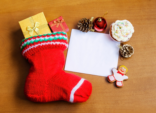 Calza di Natale con carta, regali, dolci e decorazioni su sfondo di legno
 - Foto, immagini
