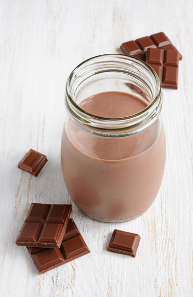 Chocolate milk with pieces of chocolate bar  - Foto, imagen
