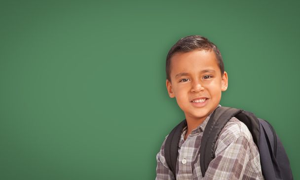 Bonito menino hispânico na frente da placa de giz em branco
 - Foto, Imagem