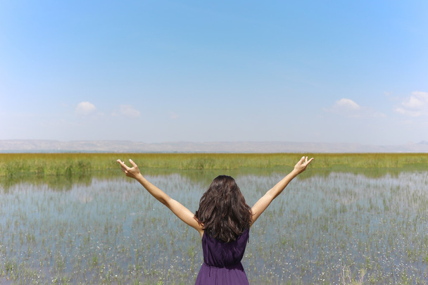 Ευτυχισμένη γυναίκα στο νεαρό πράσινο σιτάρι και λίμνη. - Φωτογραφία, εικόνα