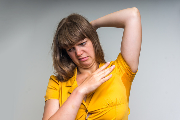 Woman with sweating under armpit in yellow dress - Photo, Image