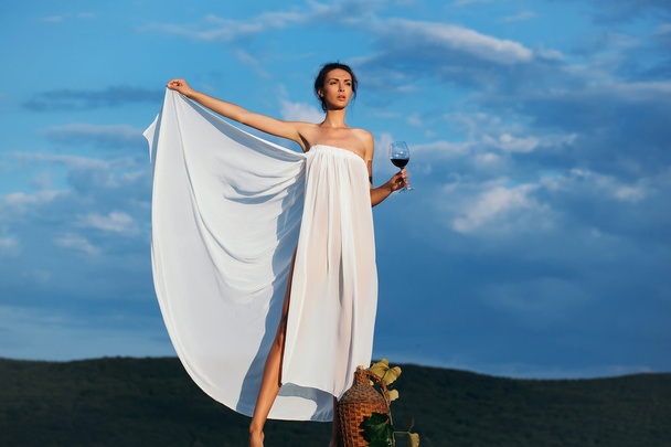 pretty girl with wine bottle over sky - Foto, Imagem