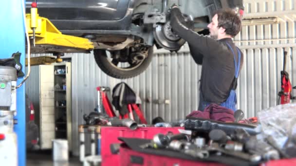 Mechanic checking car brake system in a workshop - Footage, Video
