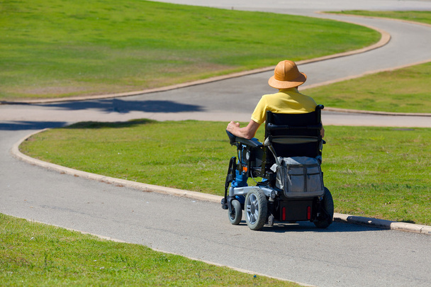 Hombre discapacitado en silla de ruedas disfrutando de aire fresco en el parque
 - Foto, imagen
