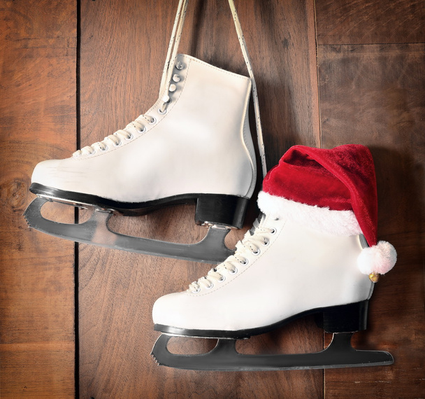 white ice skates for figure skating, hanging on wooden background - Фото, изображение
