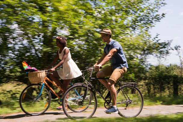 Young multiethnic couple having a bike ride in nature - Fotó, kép