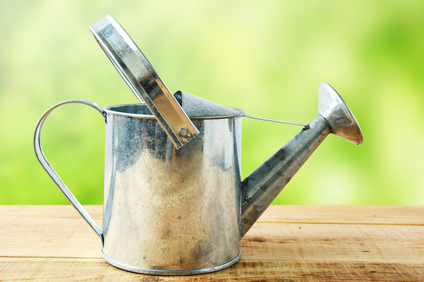 Watering can on wooden. - 写真・画像