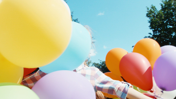 Closeup portrait happy girl spinning with balloons - Felvétel, videó