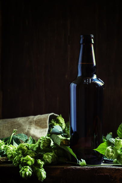 Beer with hops, dark wood background  - Fotografie, Obrázek