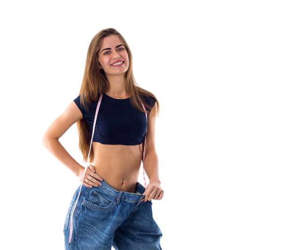 Woman wearing jeans of much bigger size - Foto, imagen