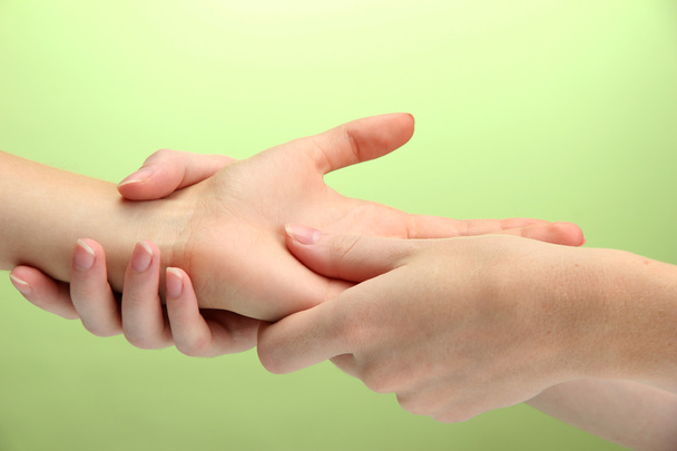 Hand massage, on green background - Foto, Imagem