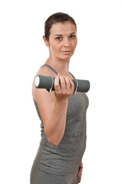 Portrait of a young pretty woman holding a dumbbell - Foto, immagini