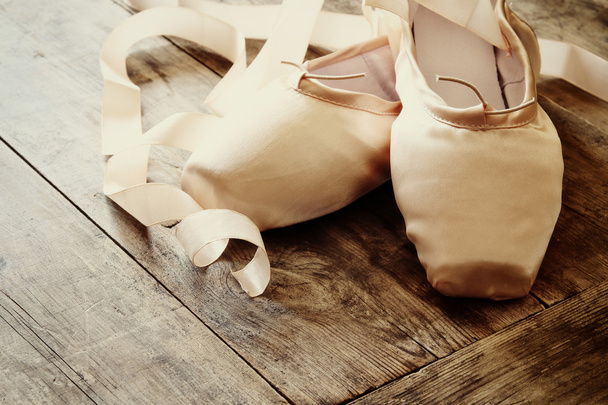 silk pointe shoes on wooden floor. Filtered and toned - Foto, afbeelding