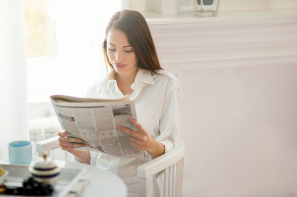 Woman reading news during breakfast - Foto, imagen