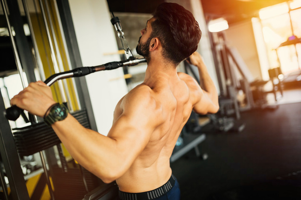 Bodybuilder working out in gym - Foto, imagen